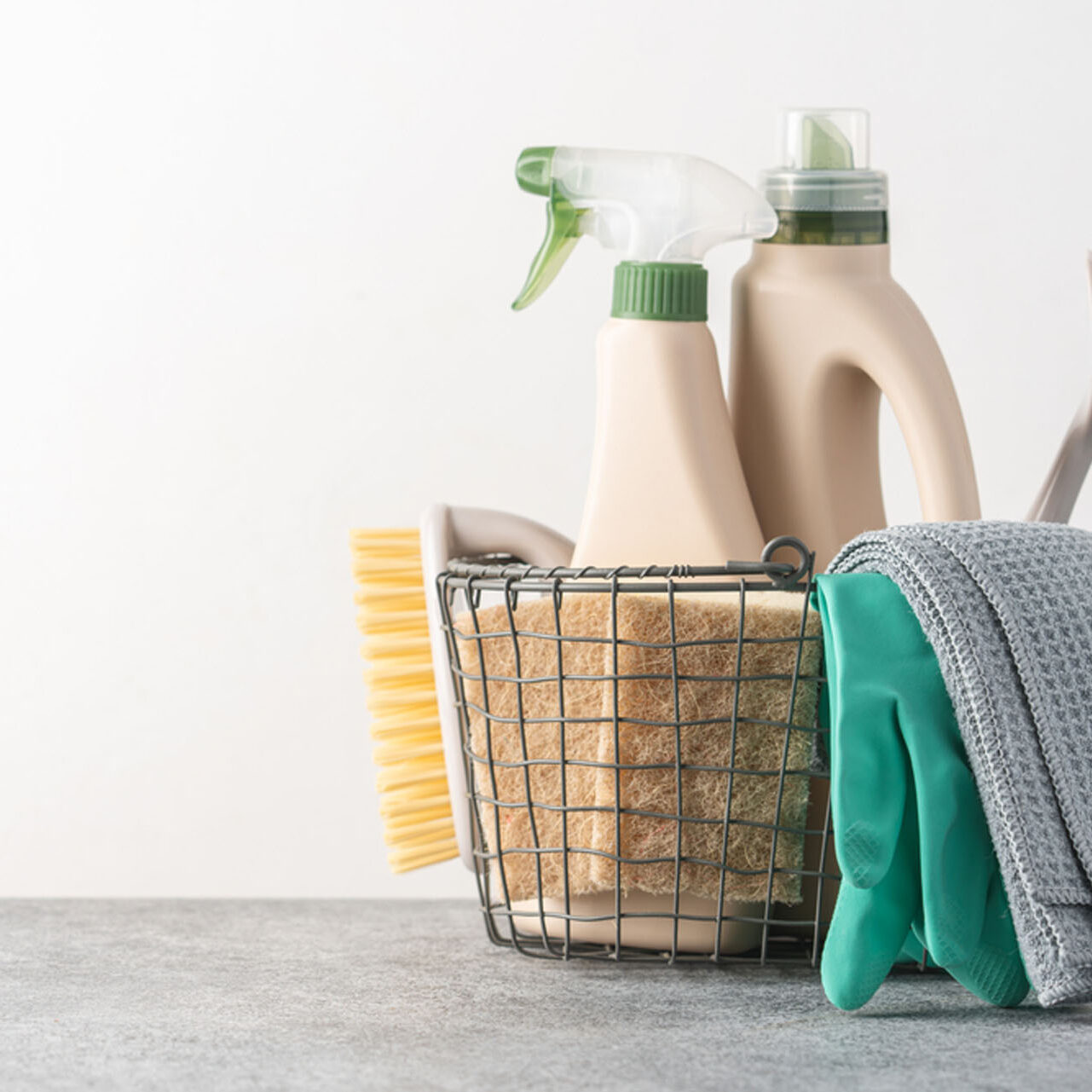 Brushes, sponges, rubber gloves and natural cleaning products in the basket.  Eco-friendly cleaning products